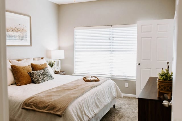 Bedroom with a queen-size bed, plush pillows, and a bedside lamp.