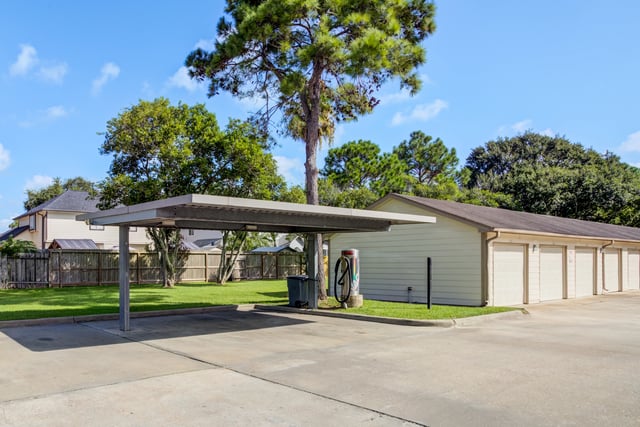 Covered parking area with garages and grassy lawn.