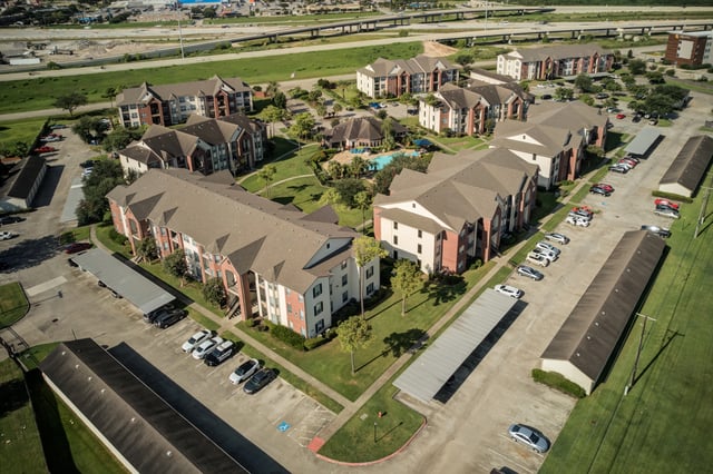 Aerial view of apartment buildings and pool area.
