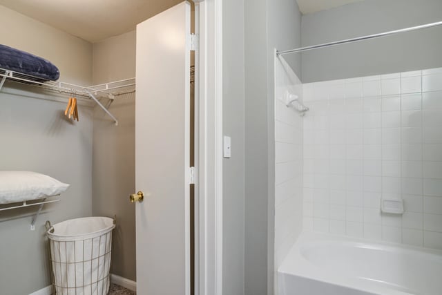 White tiled bathtub and shower in apartment bathroom