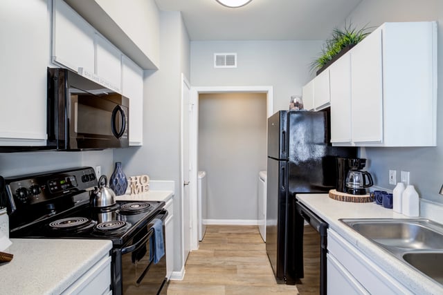 Modern kitchen with black appliances and white cabinetry.