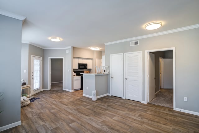 Open concept living area with a kitchen island and view into the kitchen and hallway.
