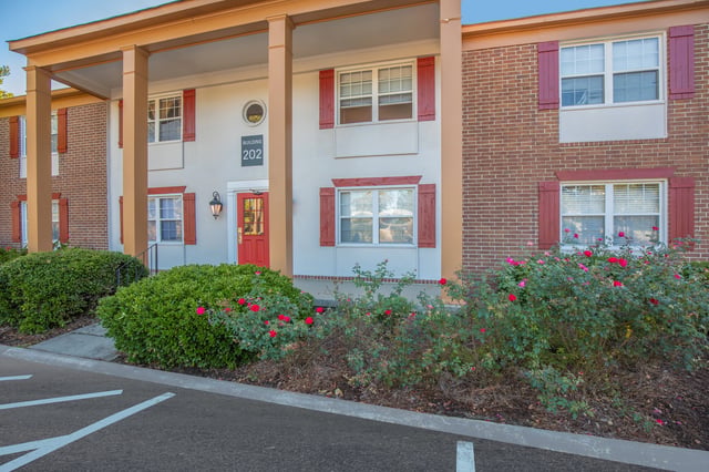 Exterior of building 202 with red shutters and a red door.