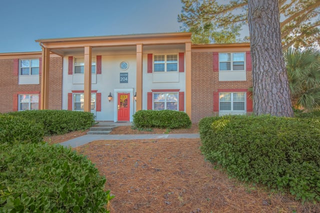 Exterior of building 204 with red door and shutters.