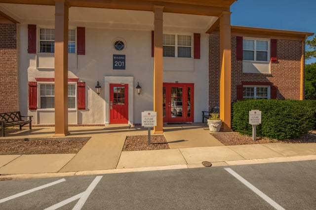 Building 201 entrance with red doors and shutters.