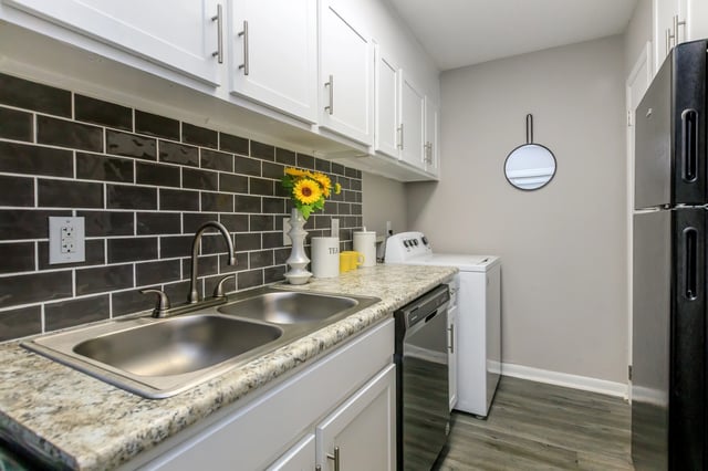 Kitchen with a double sink, dishwasher, washer, dryer, and refrigerator.