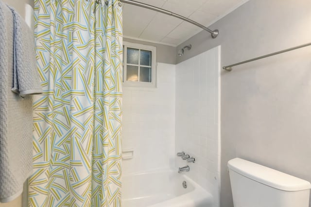 Bathtub and toilet in a bathroom with a patterned shower curtain.