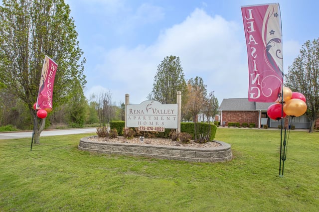Rena Valley Apartment Homes monument sign with leasing and welcome flags and balloons
