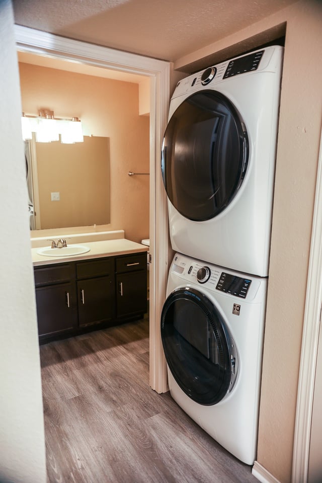 Stackable washer and dryer next to a bathroom vanity.