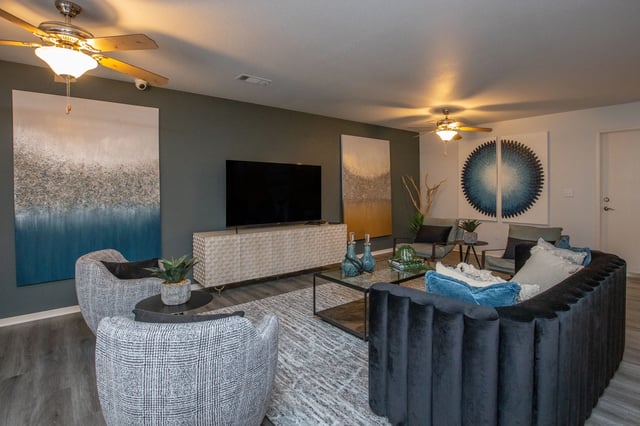 Living room with contemporary furniture, large TV, and modern art.