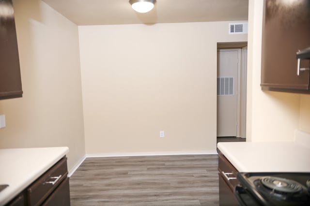 Kitchen and dining area with neutral walls and wood-look flooring.