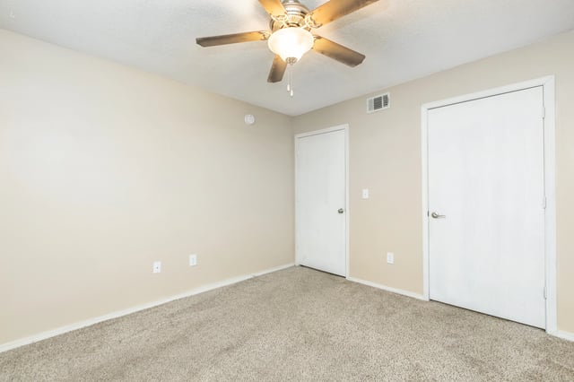 Bedroom with ceiling fan and two doors.