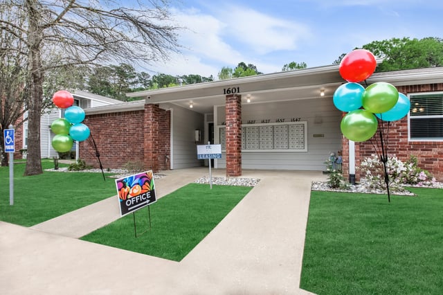 Colorful balloons and an "Office" sign greet visitors at the entrance of the apartment building.