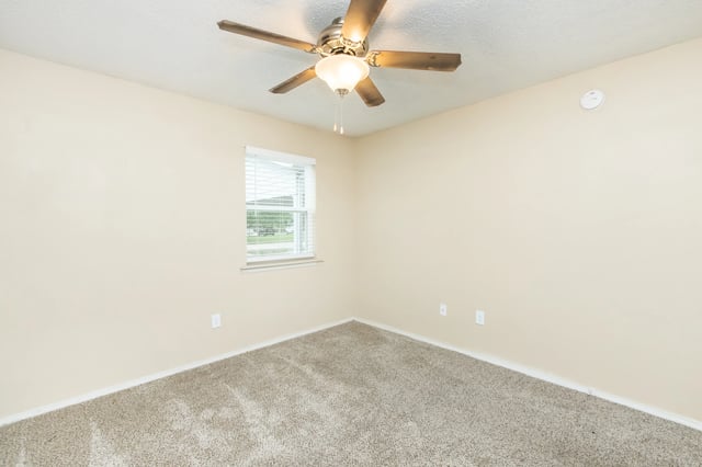 Empty bedroom with a ceiling fan and a window.