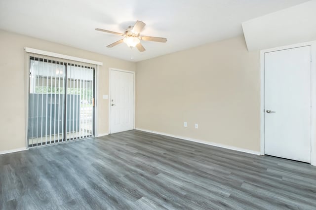 Empty living room with sliding glass door and ceiling fan