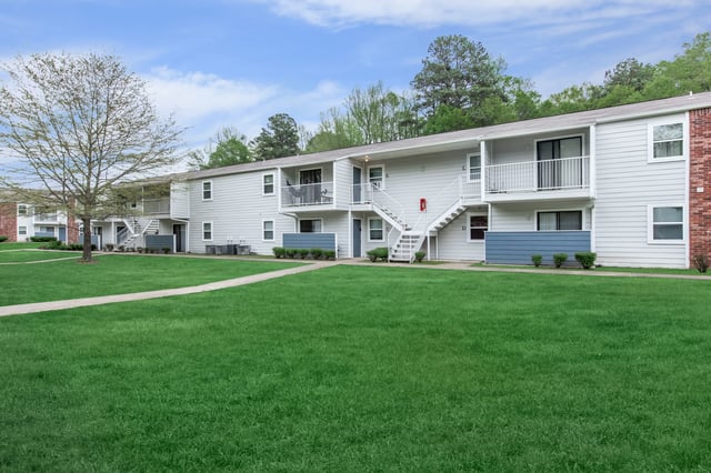 Exterior view of apartment buildings with manicured lawns and pathways.