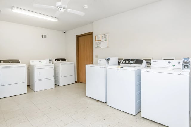 Laundry room with multiple washing machines and dryers.