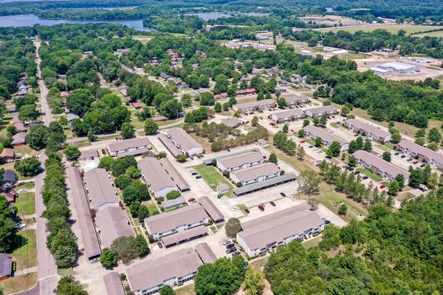 Aerial view of apartment buildings and surrounding greenery.