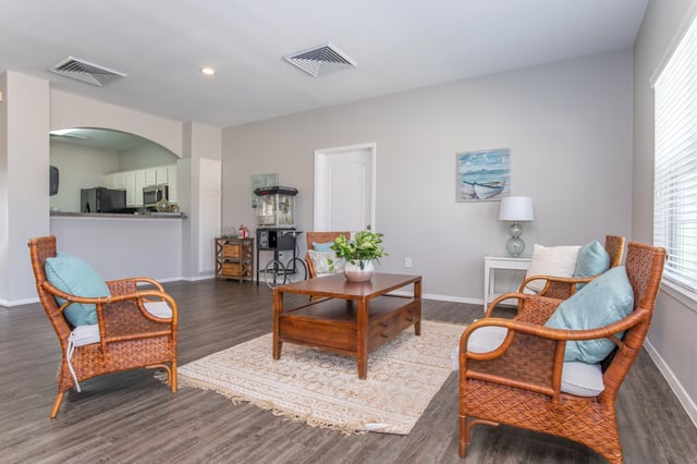 Lobby seating area with wicker chairs, a coffee table, and a popcorn machine.