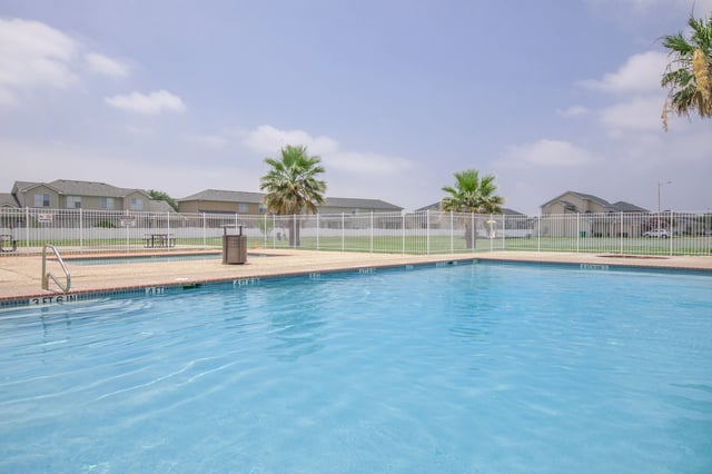 Swimming pool with palm trees and residential buildings in the background
