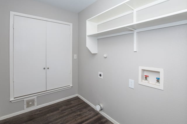Laundry hookups and shelving in a small room with double doors.