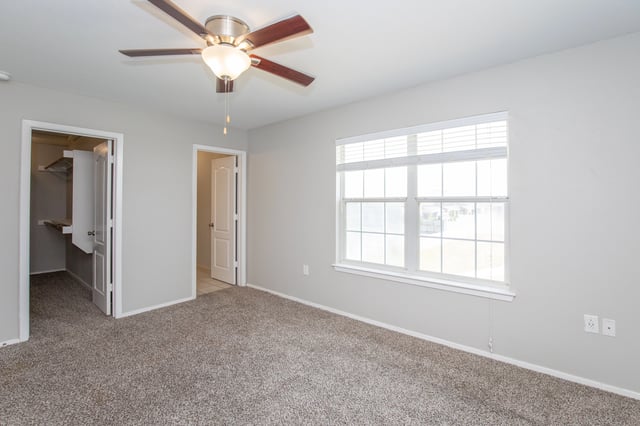 Bedroom with ceiling fan, closet, and large window