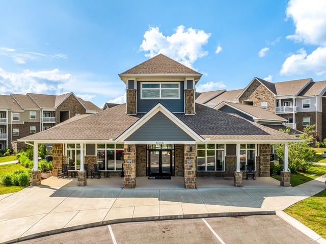 Exterior of apartment building entrance with rock accents and covered walkway.