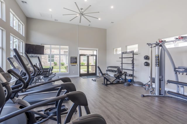Fitness center with treadmills, ellipticals, weight machines, and free weights.