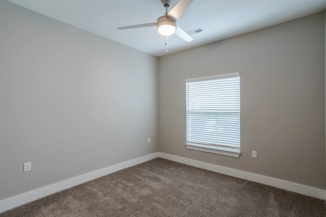 Empty bedroom with a ceiling fan and a window with blinds.