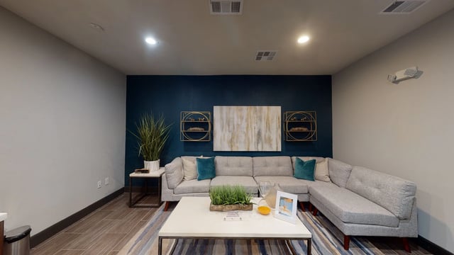 Modern living room with a sectional sofa, coffee table, and accent wall.