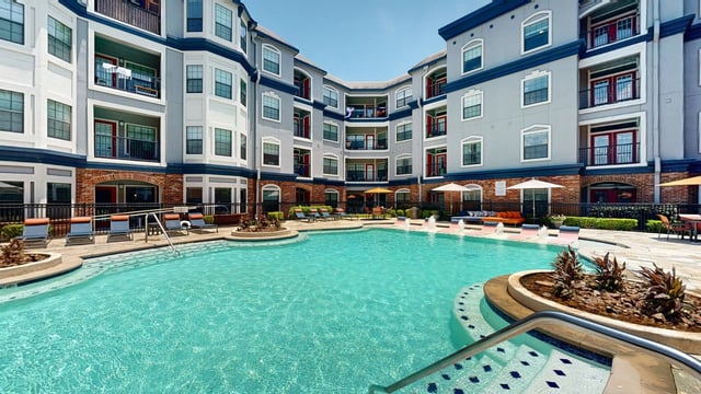 Resort-style swimming pool area with lounge chairs and outdoor seating.