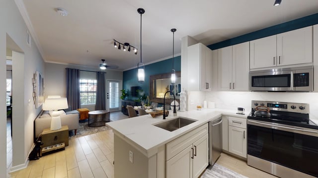 Modern kitchen with white cabinets, stainless steel appliances, and an island.