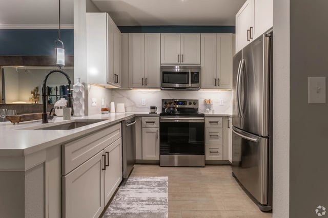Modern kitchen with stainless steel appliances, quartz countertops, and ample cabinet space.