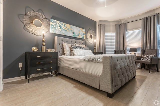 Stylish bedroom with a king-size bed, dresser, and accent chairs.