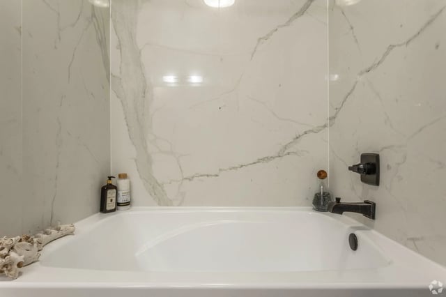 Modern bathroom with marble tile and deep soaking tub