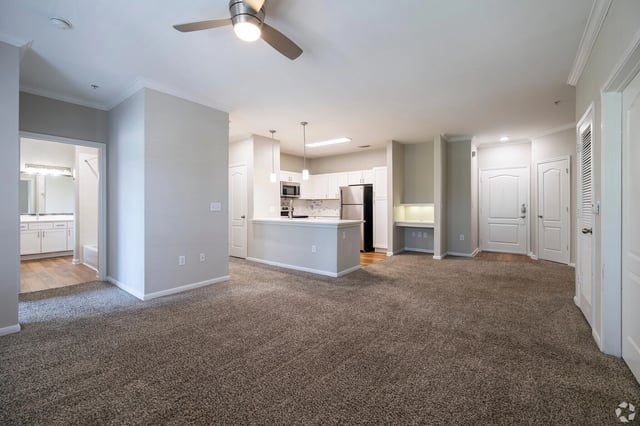 Spacious living area with open-concept kitchen and access to a bathroom.