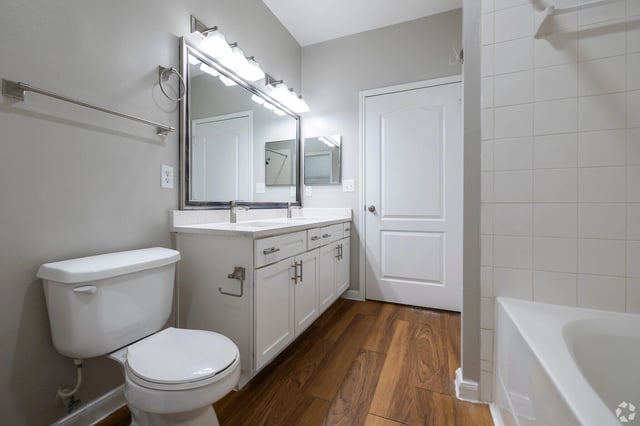 Bathroom with double vanity, toilet, and bathtub.