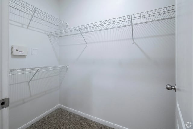 Empty walk-in closet with white wire shelving.