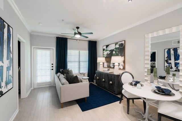 Living and dining area with a sofa, coffee table, dining table, and chairs.