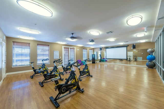 Spin bikes and exercise equipment in a fitness center.