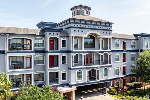 Exterior of a multi-story apartment building with balconies and a cupola.