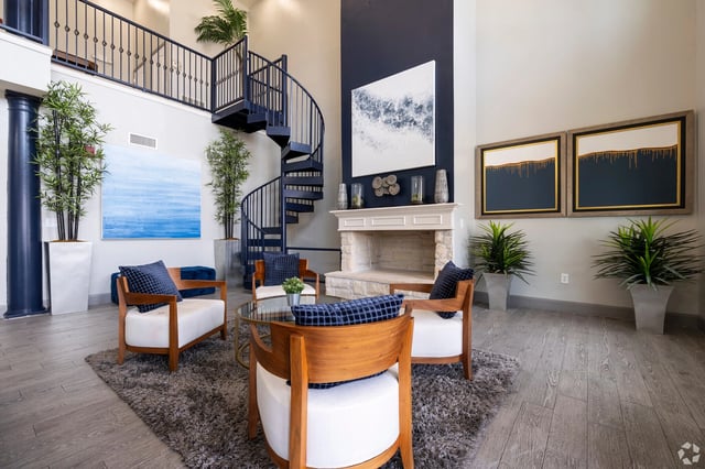 Luxurious common area with fireplace, spiral staircase, and modern seating.