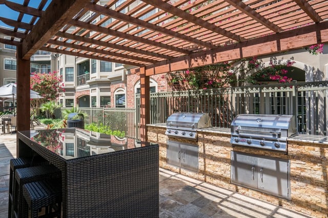 Outdoor grilling station with two built-in grills and a bar.
