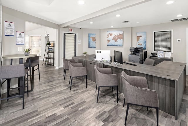 Reception desk and waiting area with world maps on the wall.
