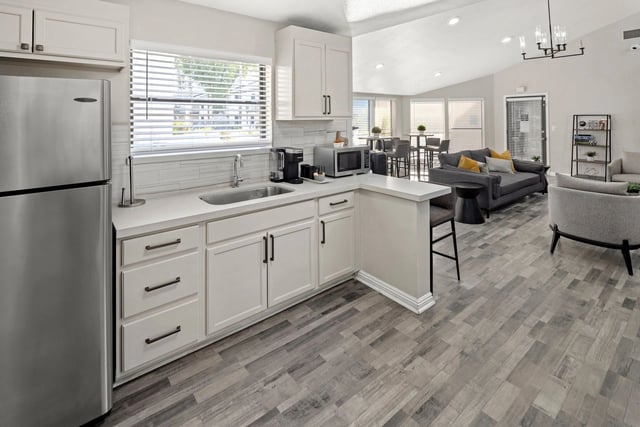 Modern kitchen with stainless steel appliances and a living area with seating.