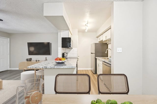 Modern kitchen with stainless steel appliances and granite countertops.
