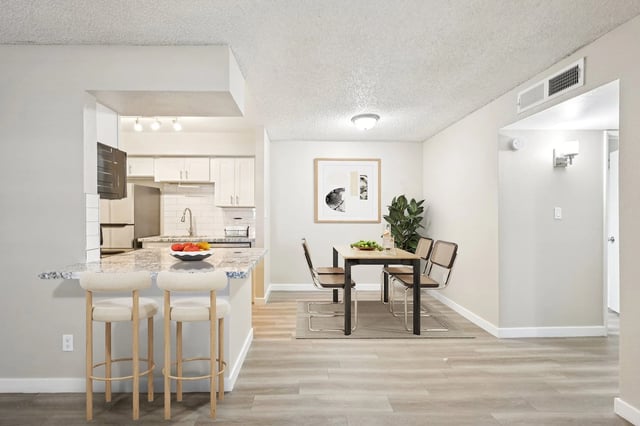 Modern kitchen and dining area with island seating and a dining table.