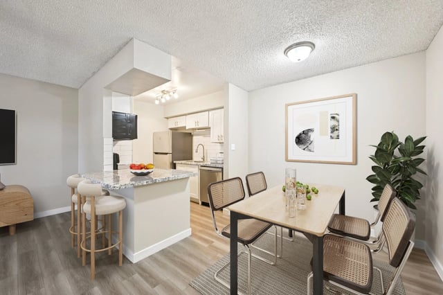 Dining area and kitchen with granite countertops, stainless steel appliances, and pendant lighting.