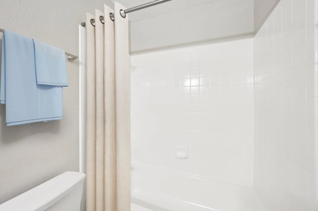 Clean white bathtub with light blue towels hanging on the wall.