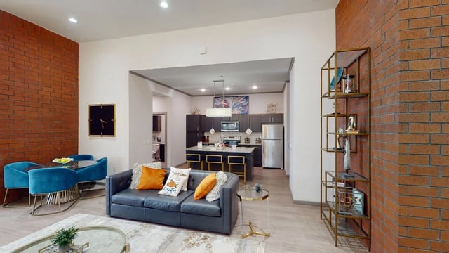 Modern living room with leather sofa, dining area, and open-concept kitchen with island.